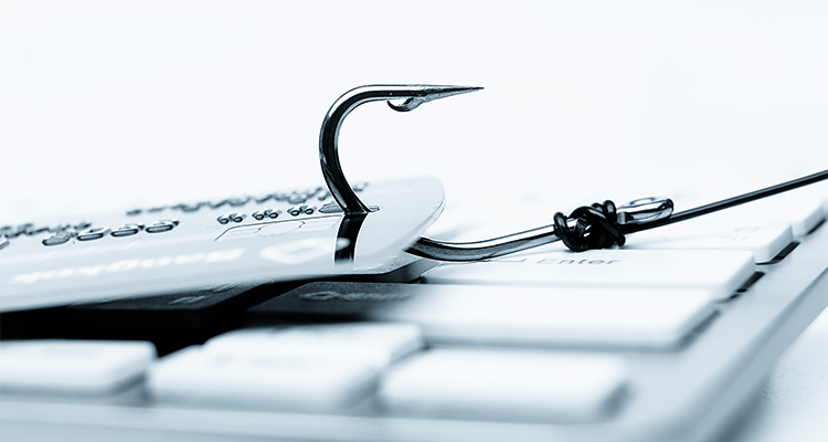 A fishing hook is pulling a credit card over a keyboard.