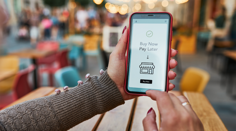 Person holding a mobile phone with a buy now pay later screen showing