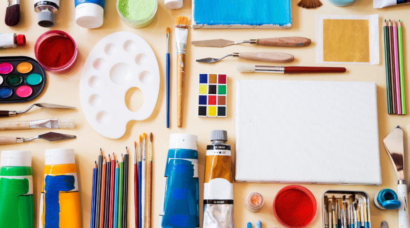 Art supplies and craft tools arranged flat, including paints, brushes, and canvas from top US craft stores.