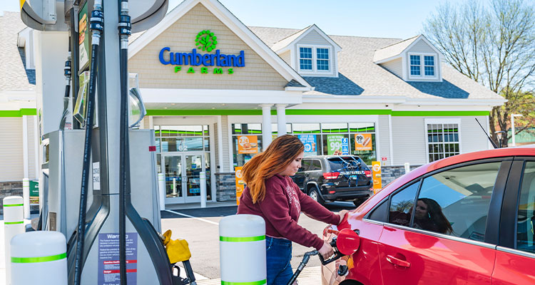 a person refueling their car at a Cumberland Farms convenience store and gas station