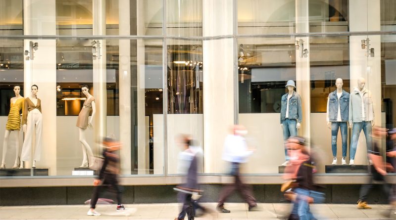 Shoppers walking past retail stores in a busy US urban shopping district