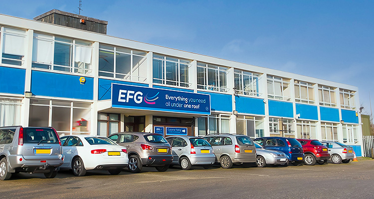 he exterior of a two-story building with a blue and white facade. A sign on the building reads "EFG" with the slogan "Everything you need all under one roof.