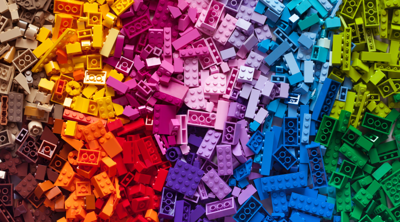 A rainbow assortment of LEGO bricks arranged by color, showcasing the variety used in detailed builds