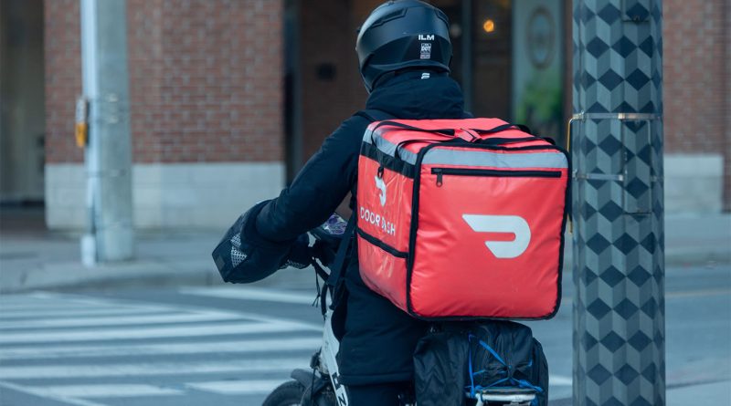 DoorDash delivery driver picking up grocery order outside a US supermarket